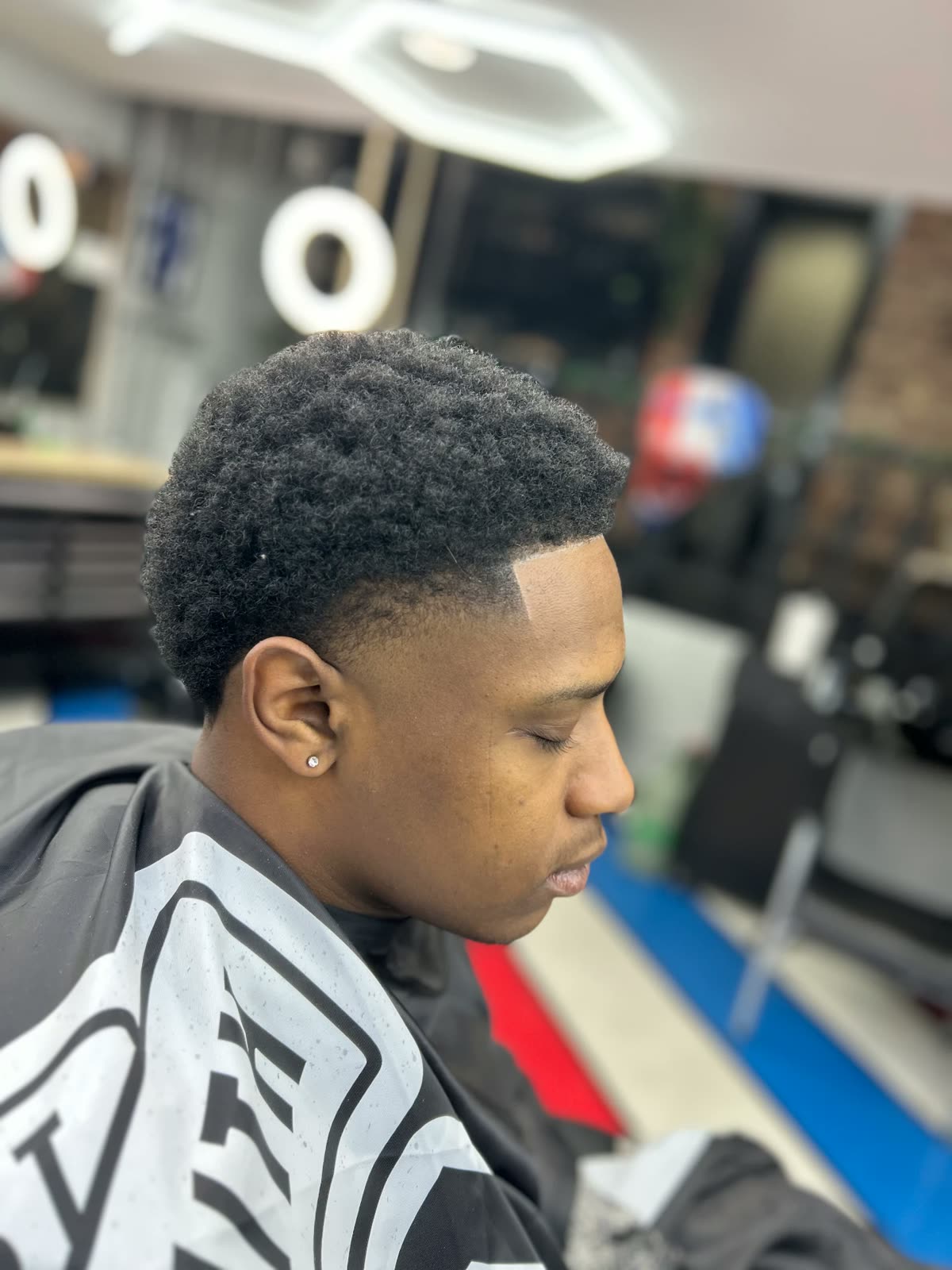 Afro with a crisp lineup and taper fade